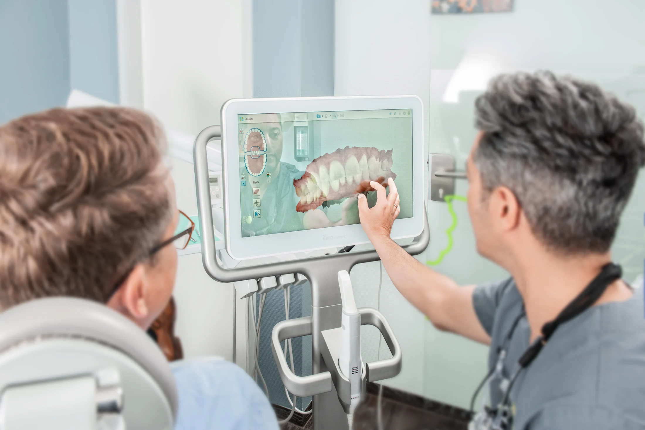 Zahnarzt Hamed Saei erklärt einem Patienten den 3D-Scan seines Gebisses am Bildschirm